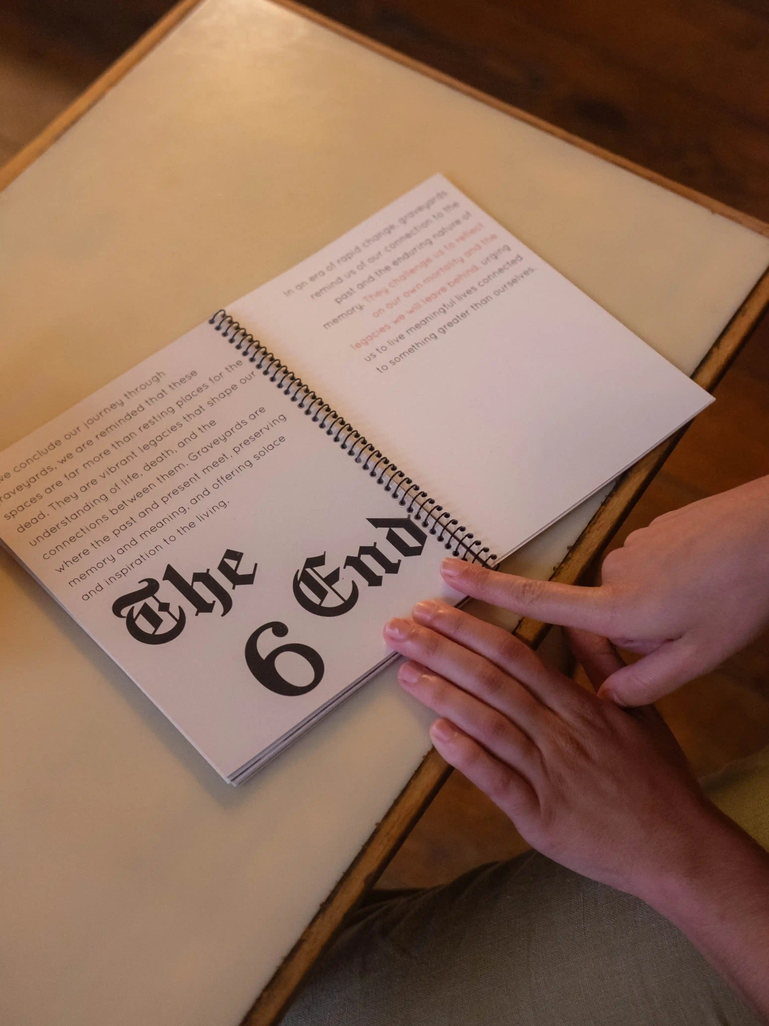 Finger pointing at 'The End' closing spread of the book